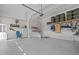 Spacious garage with white walls, storage shelves, stairs to loft and ample space for parking and projects at 2408 Eddie Howard Rd, Willow Springs, NC 27592