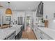 Bright, airy kitchen with white cabinetry, stainless steel appliances and hardwood flooring. Opens to dining area at 2408 Eddie Howard Rd, Willow Springs, NC 27592