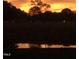 Dramatic sunset reflecting in the pond below silhouetted trees at 2408 Eddie Howard Rd, Willow Springs, NC 27592