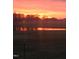Glowing sunset over a pond reflecting the trees and colors of the sky at 2408 Eddie Howard Rd, Willow Springs, NC 27592