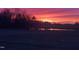 Beautiful fiery sunset over a pond, casting a colorful glow on the horizon at 2408 Eddie Howard Rd, Willow Springs, NC 27592