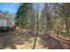 View of the backyard with a red deck visible to the left, and woods surrounding the property at 2412 Mollynick Lane Ln, Wake Forest, NC 27587