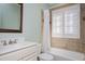 Bathroom features a shower and tub combination, white vanity, and window with white shutters at 2412 Mollynick Lane Ln, Wake Forest, NC 27587
