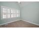 Bright bedroom featuring neutral carpet, a ceiling fan, and a large window with white shutters at 2412 Mollynick Lane Ln, Wake Forest, NC 27587