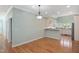 A kitchen area and dining area with hardwood floors, a modern light fixture, and light-colored walls at 2412 Mollynick Lane Ln, Wake Forest, NC 27587
