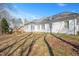 View of the home's rear exterior with a stone chimney at 2420 Mollynick Ln, Wake Forest, NC 27587