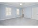 Blue bedroom with plastic covered floors, two windows with white shutters and white door at 2420 Mollynick Ln, Wake Forest, NC 27587