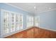 Bright bedroom featuring hardwood floors, soft blue walls, a ceiling fan, and shuttered windows at 2420 Mollynick Ln, Wake Forest, NC 27587