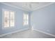 Bedroom with two windows with white shutters, blue walls, plastic covered floors and ceiling fan at 2420 Mollynick Ln, Wake Forest, NC 27587