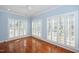 Bright bedroom featuring hardwood floors, soft blue walls, and natural light from shuttered windows at 2420 Mollynick Ln, Wake Forest, NC 27587