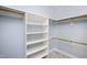 Walk-in closet with a gray carpet, wooden racks and white shelves at 2420 Mollynick Ln, Wake Forest, NC 27587