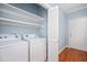 Laundry room featuring new washer and dryer, plenty of shelving, and hardwood floors at 2420 Mollynick Ln, Wake Forest, NC 27587