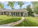 Charming single-story home featuring manicured lawn, flower beds, and a curved walkway leading to the front door at 2617 Cottage Cir, Raleigh, NC 27613