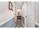 Hallway features stylish wainscoting, hardwood floors with a runner, and framed artwork on the walls at 2617 Cottage Cir, Raleigh, NC 27613