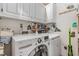 Practical laundry room includes a modern washer and dryer, plus overhead storage cabinets at 2617 Cottage Cir, Raleigh, NC 27613
