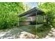 Modern exterior showcasing a covered carport with natural surroundings at 2713 Mcdowell Rd, Durham, NC 27705