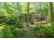 Contemporary home nestled in a lush, green wooded area, surrounded by mature trees and landscaping at 2713 Mcdowell Rd, Durham, NC 27705