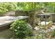 Contemporary home featuring a flat roof, complemented by beautiful landscaping and natural wooded surroundings at 2713 Mcdowell Rd, Durham, NC 27705