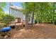Home's backyard with wooden deck, mature trees, and a charcoal grill at 3008 Isabella Dr, Raleigh, NC 27603