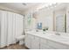 Bright bathroom featuring dual sinks, a large mirror, and a shower with curtain at 3008 Isabella Dr, Raleigh, NC 27603
