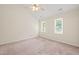 Bright bedroom featuring neutral carpet, ceiling fan, and two sun-filled windows at 3008 Isabella Dr, Raleigh, NC 27603
