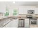 Close-up of the bright kitchen featuring stainless steel appliances and granite countertops at 3008 Isabella Dr, Raleigh, NC 27603