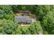 Aerial view of a beautiful home nestled among trees with a play set and brick patio at 313 Shetland Rd, Rougemont, NC 27572