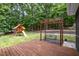 Backyard space features a deck with swing and a playset surrounded by lush landscaping at 313 Shetland Rd, Rougemont, NC 27572