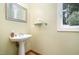 Powder room featuring pedestal sink, a framed mirror, a glass shelf and tile floors at 313 Shetland Rd, Rougemont, NC 27572