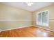 Empty bedroom featuring hardwood flooring, neutral-toned walls, a ceiling fan, and large window with blinds at 313 Shetland Rd, Rougemont, NC 27572