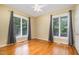 Empty bedroom with hardwood flooring, large window with curtains, and ceiling fan at 313 Shetland Rd, Rougemont, NC 27572