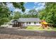 Beautiful backyard with play set, deck, screen porch, and landscaped areas at 313 Shetland Rd, Rougemont, NC 27572