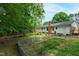 Spacious backyard with garden beds, lush greenery, and a view of the home's exterior at 3517 Morningside Dr, Raleigh, NC 27607