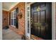 Elegant black front door with decorative hardware, sidelight, and seasonal decorations creating a warm entrance at 3619 Lion Ridge Ct, Raleigh, NC 27612