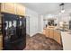 Well-lit kitchen featuring brown tile floor, stainless steel sink, and a modern black refrigerator at 3619 Lion Ridge Ct, Raleigh, NC 27612