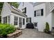 Backyard featuring a stone patio, grill, and a charming white-brick house with green shutters at 3816 Dover Rd, Durham, NC 27707