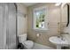 Classic bathroom features a toilet, sink, and shower with floral wallpaper and a window view at 3816 Dover Rd, Durham, NC 27707