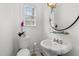 Charming powder room with pedestal sink, toilet, and window allowing natural light in a clean design at 3816 Dover Rd, Durham, NC 27707