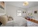 Bright bedroom showcasing hardwood floors, white walls and trim, and natural light through two windows at 3816 Dover Rd, Durham, NC 27707