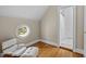 Comfortable bonus room with a round window, hardwood floors, and access to an adjoining bathroom at 3816 Dover Rd, Durham, NC 27707