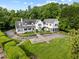 Aerial view of a stunning white home with manicured lawns and mature landscaping at 3816 Dover Rd, Durham, NC 27707