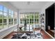 Bright sunroom with large windows, a glass desk, and a unique floor covering, perfect for a home office at 3816 Dover Rd, Durham, NC 27707