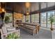 An inviting sunroom with a stone fireplace, dining table, bench, and large windows offering scenic views at 3816 Dover Rd, Durham, NC 27707