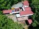 Overhead view of home with outdoor seating, garden plots and patio, all surrounded by dense forestry at 382 Valley Ln, Pittsboro, NC 27312