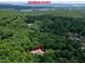 Overhead image of a red-roofed residence surrounded by lush greenery near Jordan Lake, showing its secluded location at 382 Valley Ln, Pittsboro, NC 27312