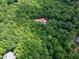 A high-angle shot of a home nestled in dense forestry, identifiable by its red roof and marked with a pin at 382 Valley Ln, Pittsboro, NC 27312