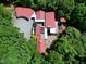 Beautiful aerial shot of a secluded property nestled among dense trees, showcasing its red roofs and spacious layout at 382 Valley Ln, Pittsboro, NC 27312