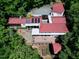 Expansive property with a red roof, wooden deck and lush landscaping seen from above, in a serene setting at 382 Valley Ln, Pittsboro, NC 27312