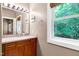 Bathroom vanity with a granite top, mirror, and a large window with a wooded view at 382 Valley Ln, Pittsboro, NC 27312