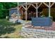 Exterior view of the home featuring wooden support beams, stone walls, and lush landscaping at 382 Valley Ln, Pittsboro, NC 27312